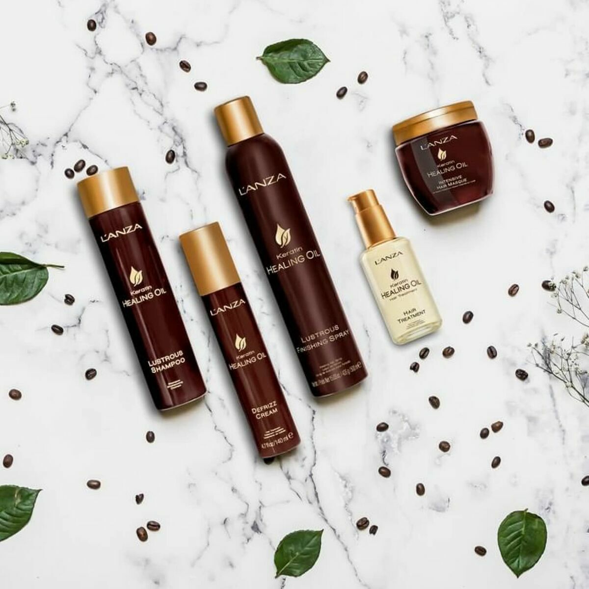 Gamme de produits L'ANZA Keratin Healing Oil sur marbre, incluant shampooing, après-shampooing et traitement.