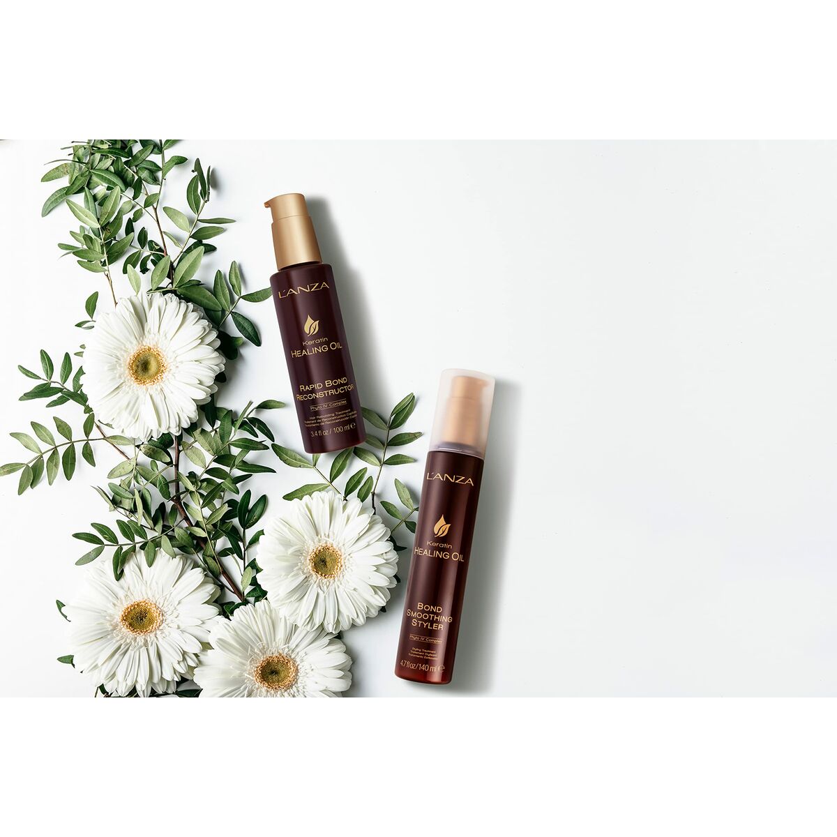 Crème stylisant L'ANZA Keratin Healing Oil et L'ANZA Healing Oil sur fond de fleurs blanches et feuillage.