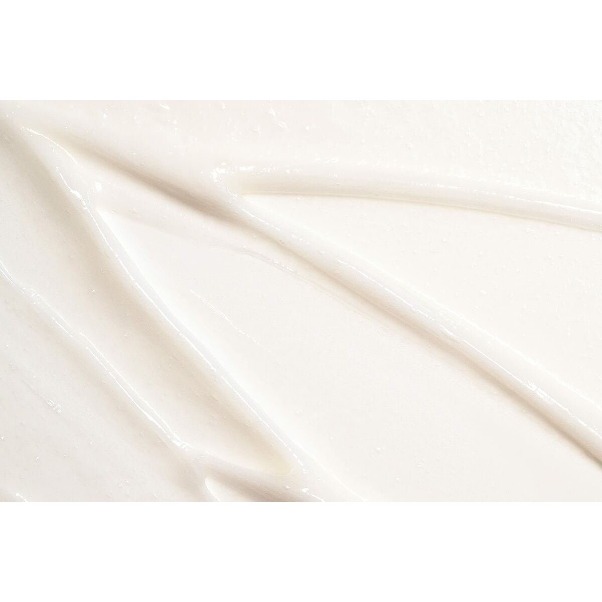 Textured close-up of creamy L'ANZA Healing Curls conditioner, highlighting its smooth and luxurious consistency.
