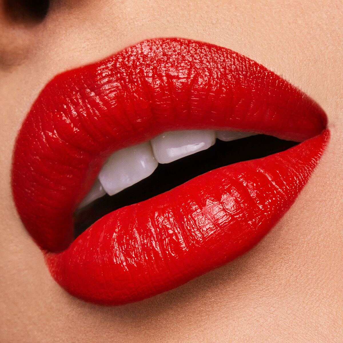 Gorgeous close-up of bold red lips wearing Estee Lauder Pure Color Carnal lipstick, showcasing a glossy and seductive finish.