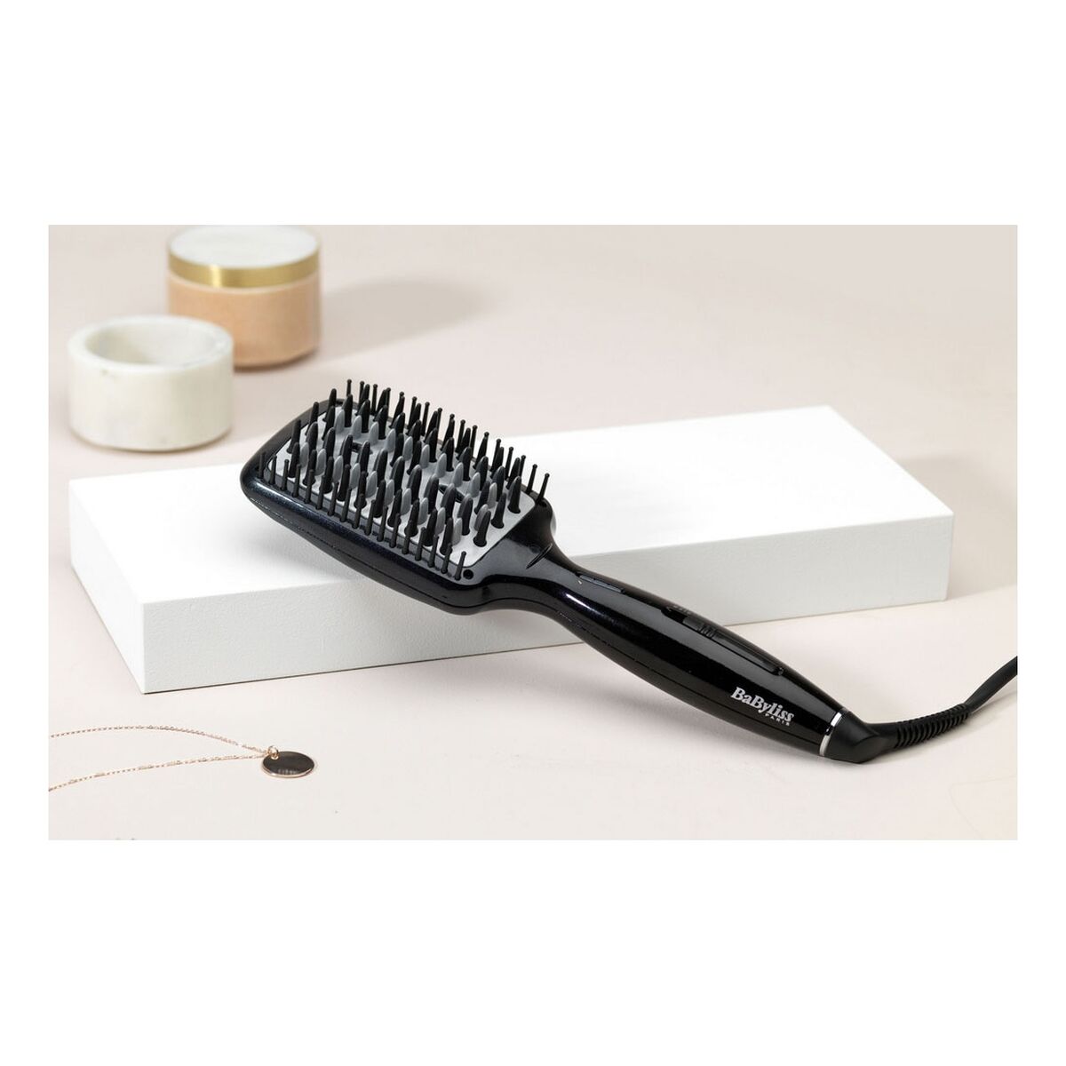 Brosse Babyliss HSB101E en céramique noire sur fond neutre avec accessoires de coiffure.