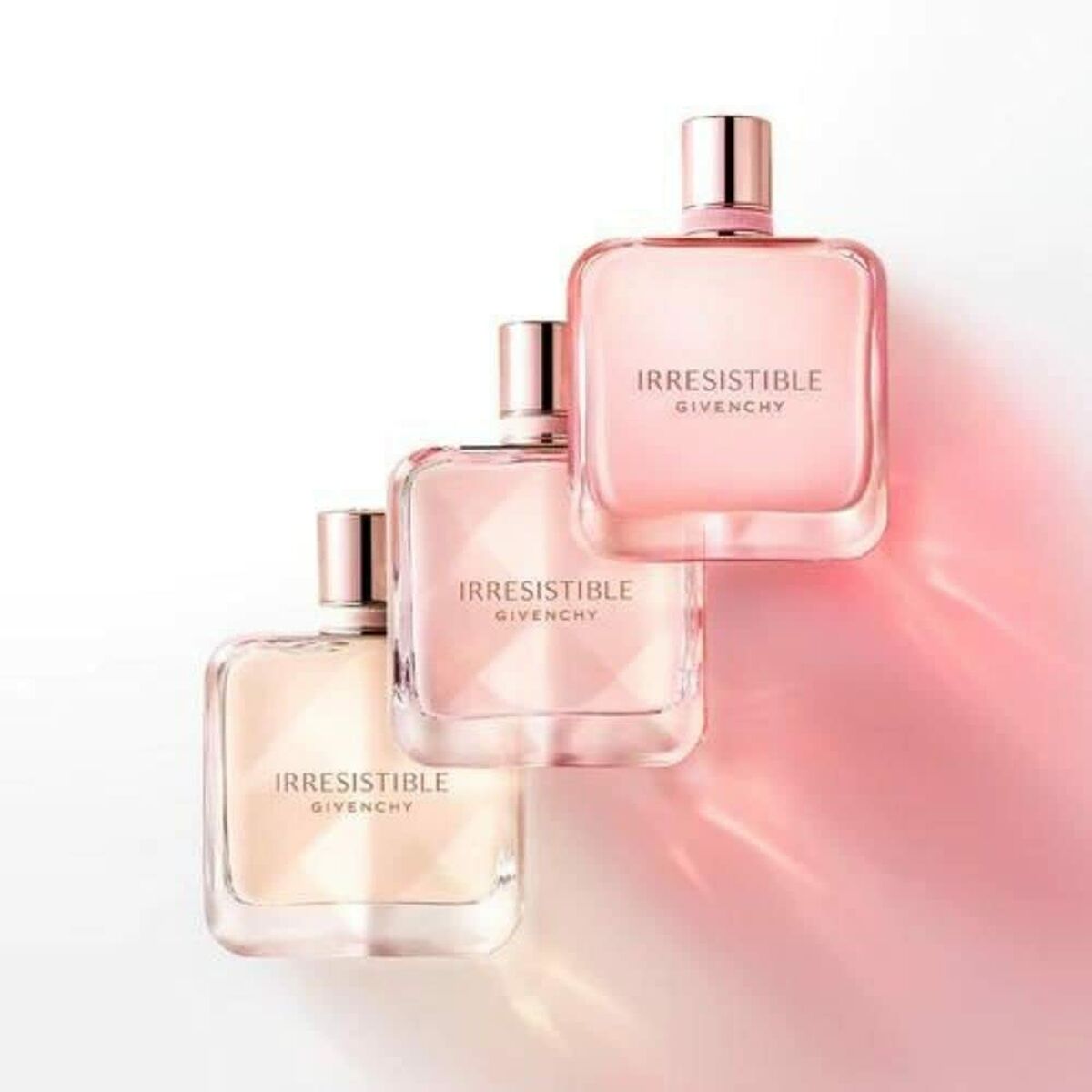 Three Givenchy Irrésistible perfumes on a gradient background, showcasing elegance and femininity.