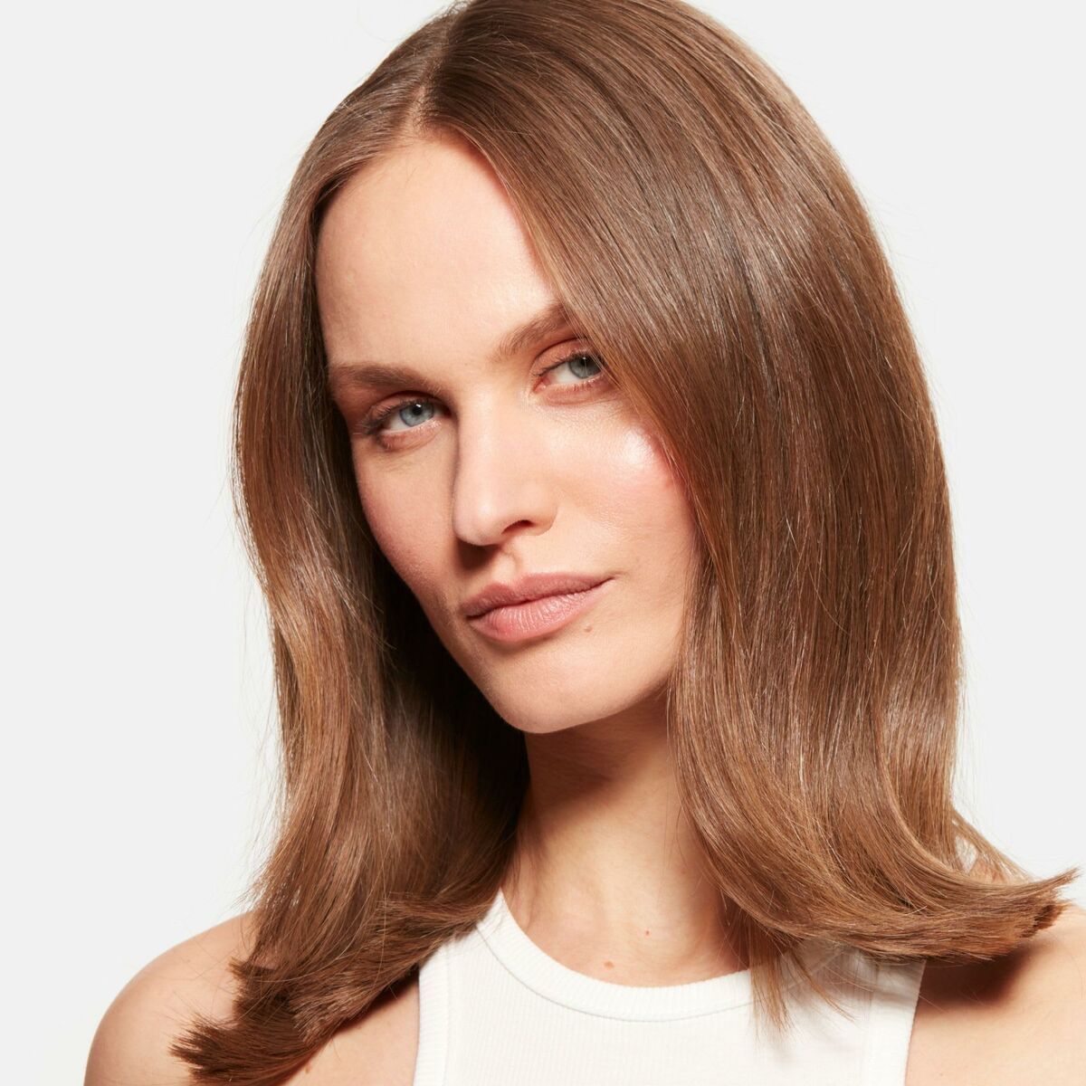 Femme avec cheveux lisses et brillants, affichant une esthétique de beauté moderne et soignée.