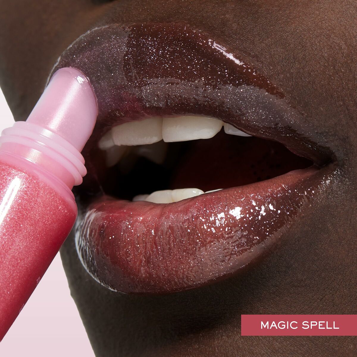 Close-up of glossy lips applying Lancôme Juicy Tubes in 'Magic Spell' shade for a luscious look.