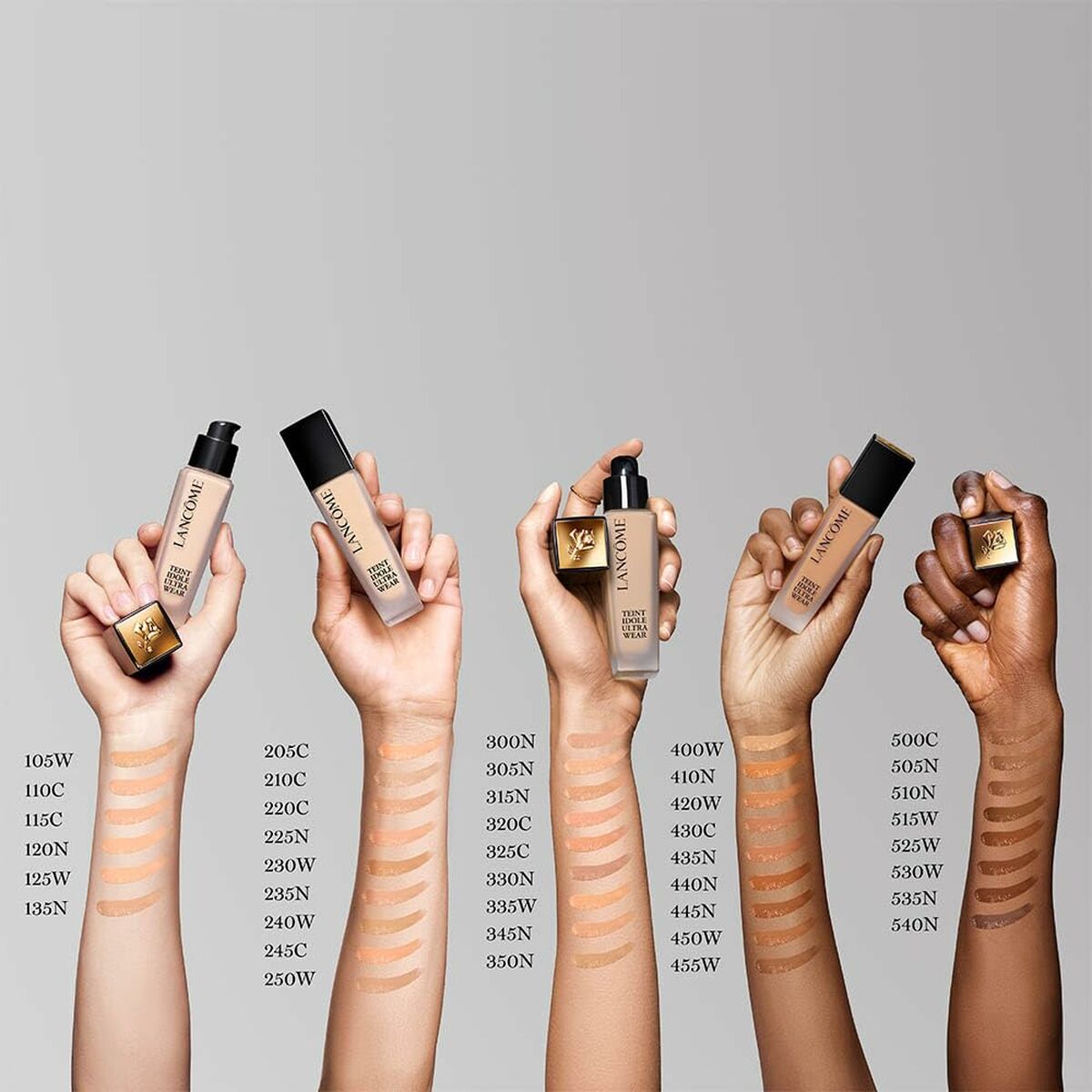 Hands showcasing Lancôme Teint Idole Ultra Wear foundation shades and swatches for various skin tones.