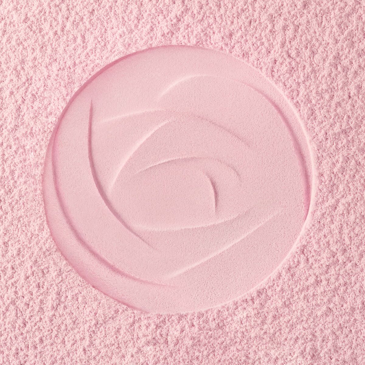 Textured pink cosmetic powder featuring a rose design, ideal for makeup application.