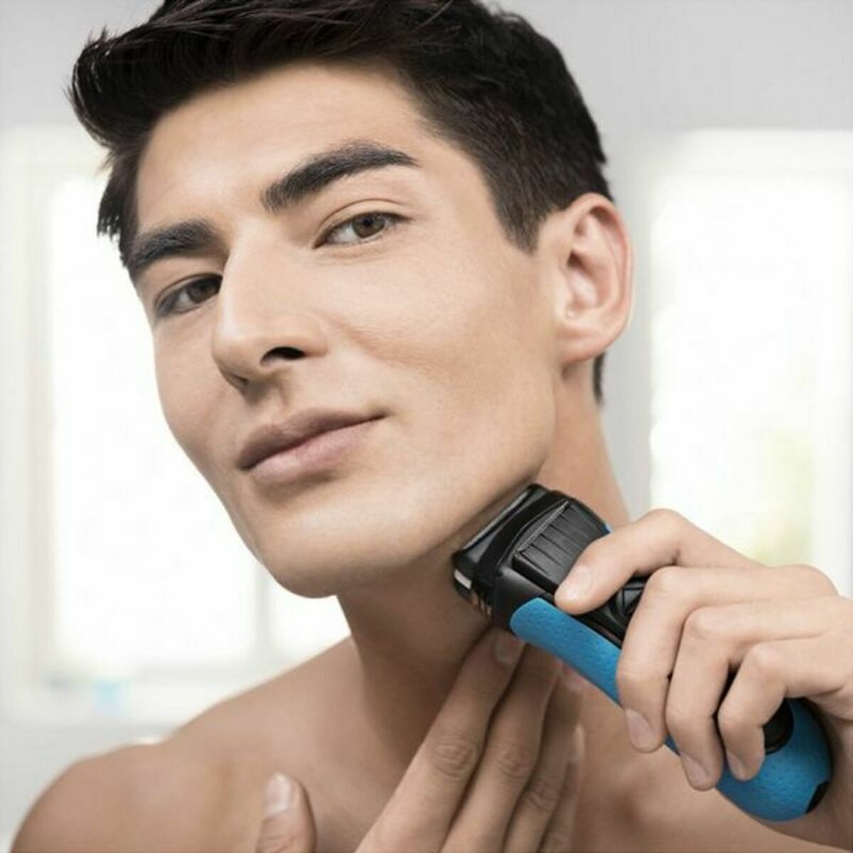 Homme utilisant le rasoir électrique Braun Series 3 3000S pour le soin du visage, couleur noire et bleue.