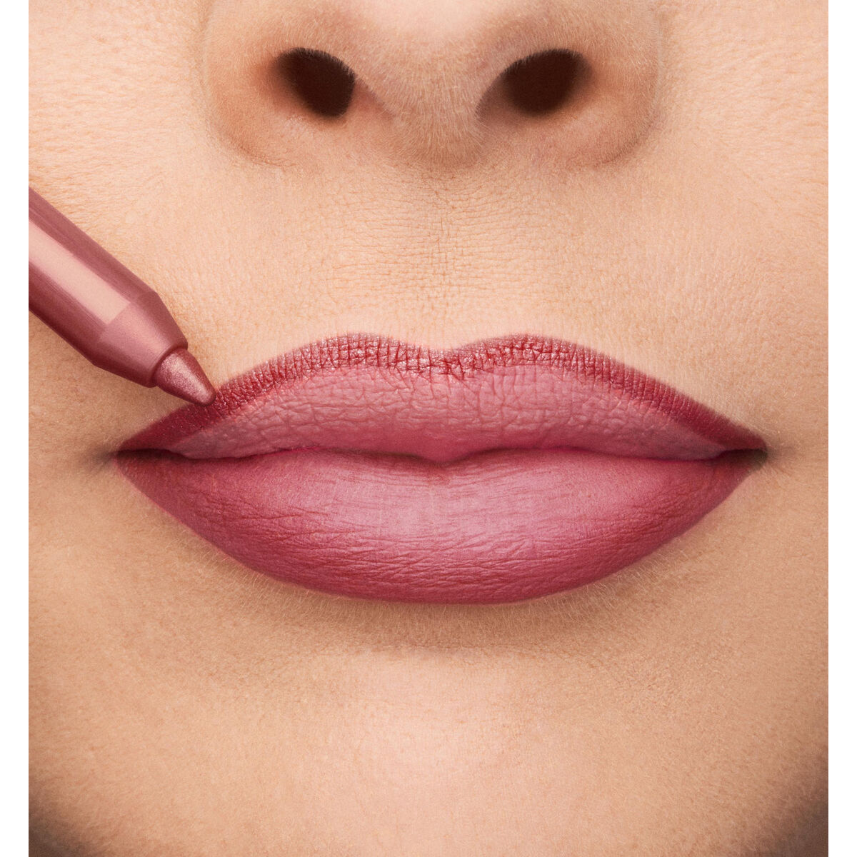Close-up of lips being lined with a rose pink lip pencil for a polished look, showcasing the Rouge à lèvres Collistar Professionale.