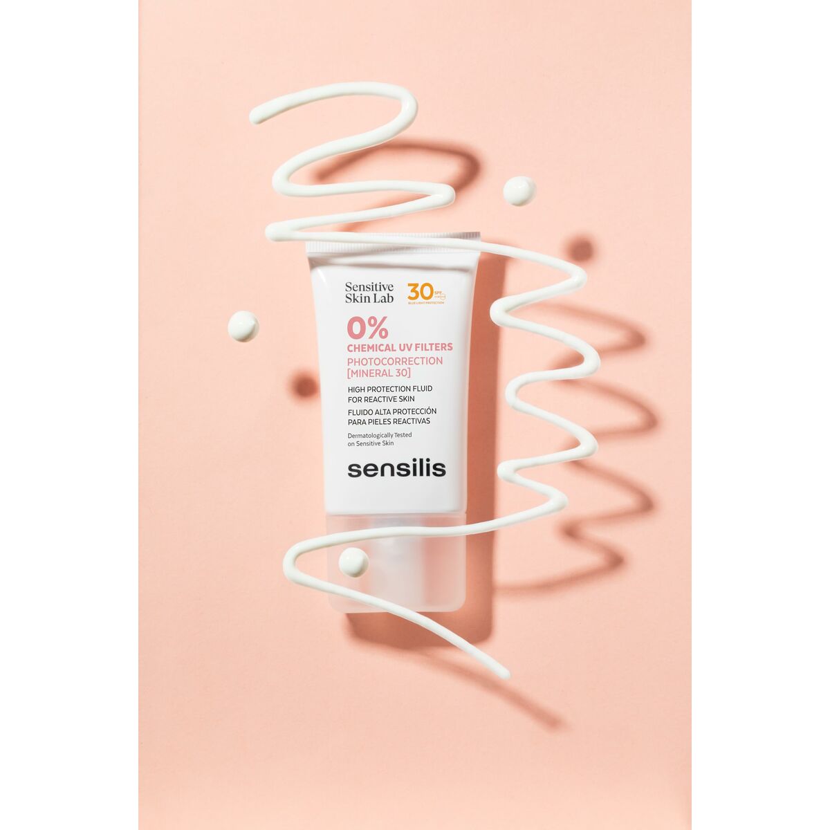 Sunscreen product Écran solaire visage Sensilis PHOTOCORRECTION with SPF 30 on a pink background.