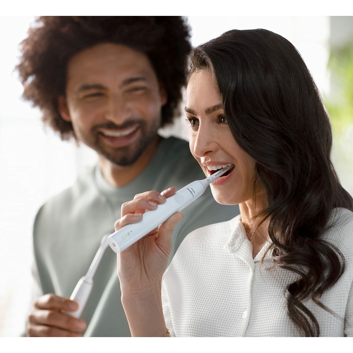 Femme utilisant la brosse à dents électrique Philips HX3651/13, améliorant son hygiène buccale avec un sourire.