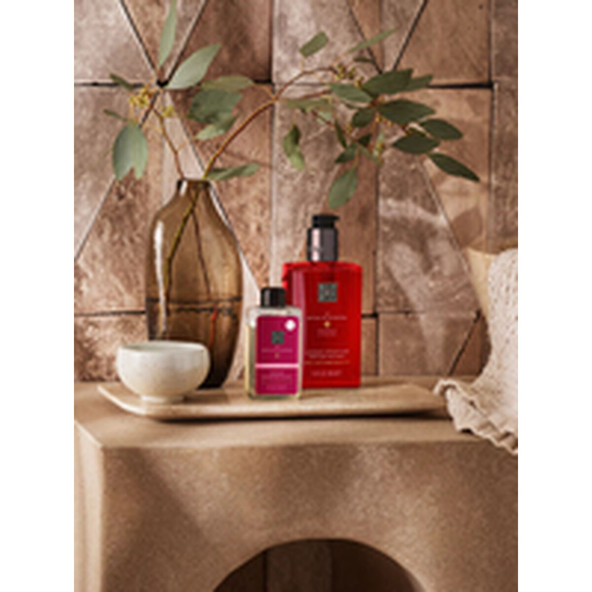 Stylish display of Rituals shower gels alongside a vase and decorative bowl, set on a modern wooden surface.