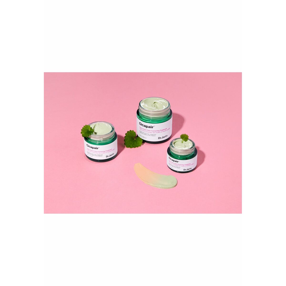 Trois pots de correcteur facial DR.JART+ CICAPAIR sur fond rose, idéal pour les peaux sensibles.